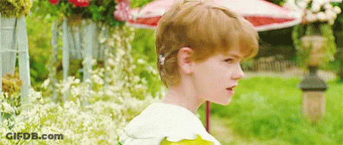 Red-Haired Boy With Flower In Garden GIF