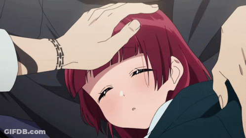 Red-Haired Girl Laying On Ground With Man's Hand On Forehead GIF