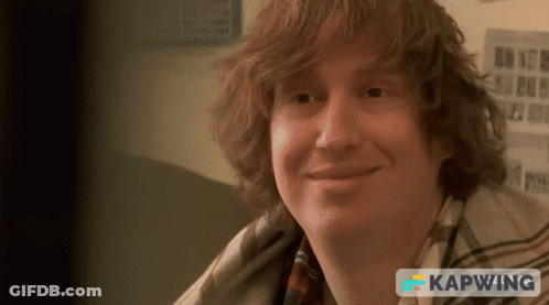 Red-Haired Man Smiling In Front Of Kapwing Sign GIF