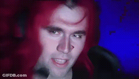 Red-Haired Man With Horn Looking At Camera GIF