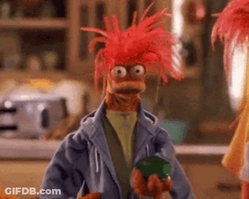 Red-Haired Muppet In Blue Jacket Holding Green Jar GIF