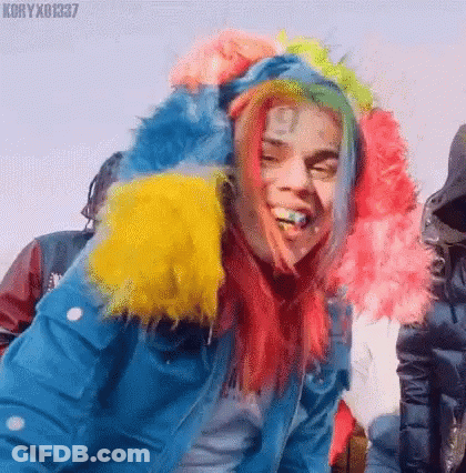 Red-Haired Rainbow-Wigged Man In Blue Jacket, Rainbow Hood GIF