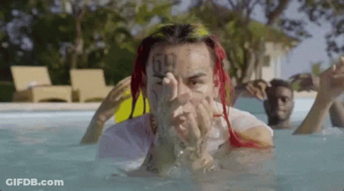 Red-Haired Tattooed Man Laying In Pool GIF