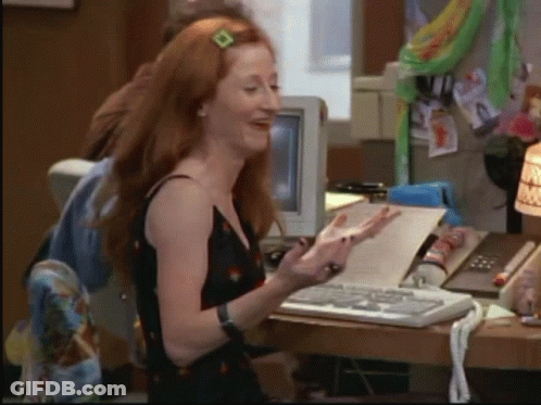 Red-Haired Woman At Desk With Paper GIF