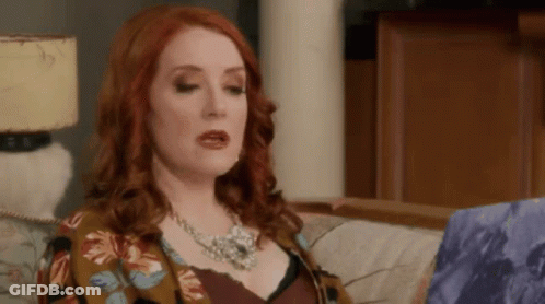 Red-Haired Woman In Floral Jacket And Necklace GIF