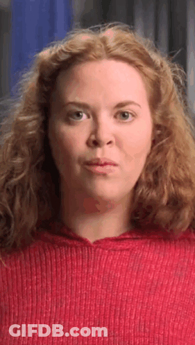 Red-Haired Woman In Red Sweater Making Face GIF