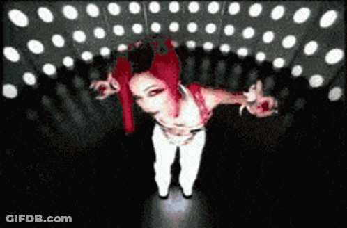 Red-Haired Woman In White Pants In Dark Room GIF