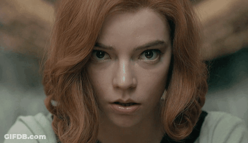Red-Haired Woman Looking Seriously At Camera GIF