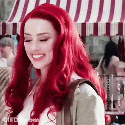 Red-Haired Woman Smiling At Striped Canopy GIF