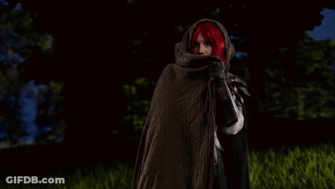 Red-Haired Woman Standing In Field With Lurking GIF