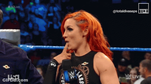 Red-Haired Woman Talking To Man In Wrestling Ring Wearing Black Lab Top GIF