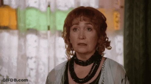Red-Haired Woman With Black Necklace Looking At Camera GIF