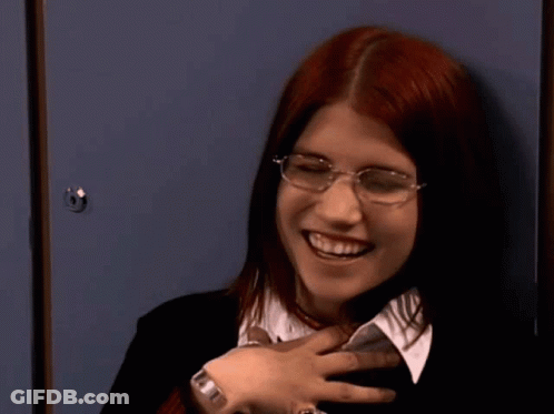 Red-Haired Woman With Glasses Smiling At Blue Locker GIF