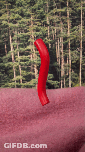 Red Object Floating On Pink Surface In Front Of Forest GIF