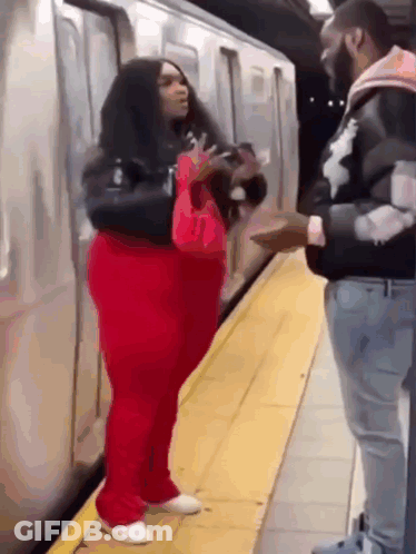 Red Pants Woman Talking To Black Jacket Man GIF