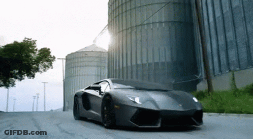 Red Robot With Horn Standing In Front Of Yellow Truck GIF