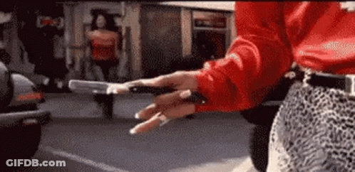 Red Shirt Woman With Leopard Skirt Holding Gun GIF