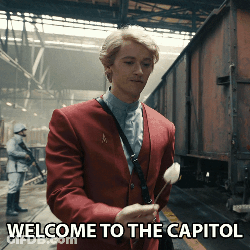 Red Suit Man Holds Flower Welcome To Capitol GIF