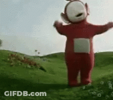 Red Teletubbies Standing In Grassy Field GIF