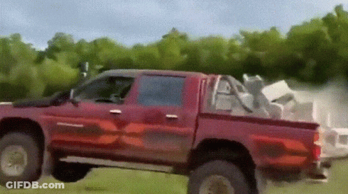 Red Truck Driving On Grassy Field GIF