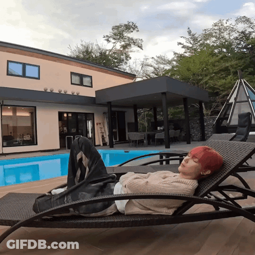 Redhead On Lounge Chair In Front Of House GIF
