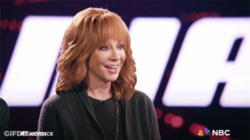 Redhead Smiling In Front Of NBC Logo GIF