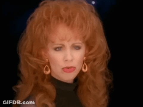 Redhead Woman In Black Turtleneck Making Funny Face GIF