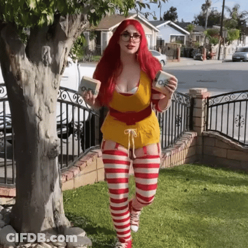 Redhead Woman In McDonald's Costume Standing In Front Of Tree GIF