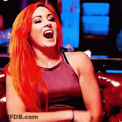 Redhead Woman Laughing On Red Couch GIF