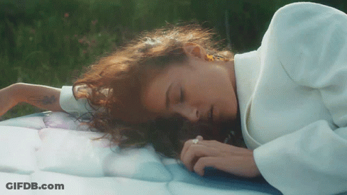 Redhead Woman Laying On Blue Blanket Eyes Closed GIF