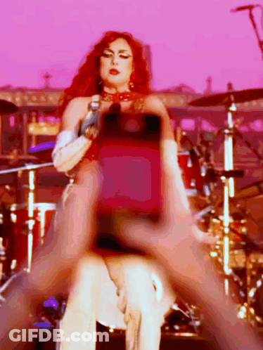 Redhead Woman Singing Into Microphone At Drum Set GIF