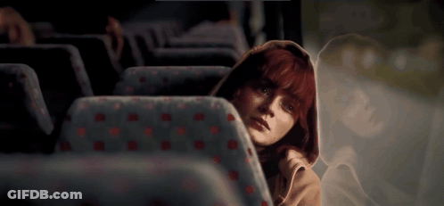 Redhead Woman Sitting In Bus With Reflection GIF