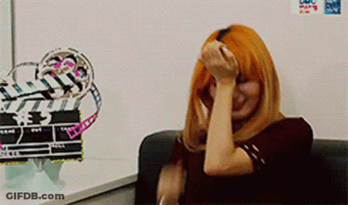Redhead Woman Sitting In Front Of White Board With Sticker GIF