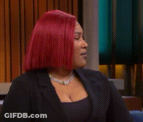 Redhead Woman Sitting On Couch With Hands In Air GIF