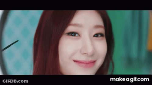 Redhead Woman Smiling In Front Of Clock GIF