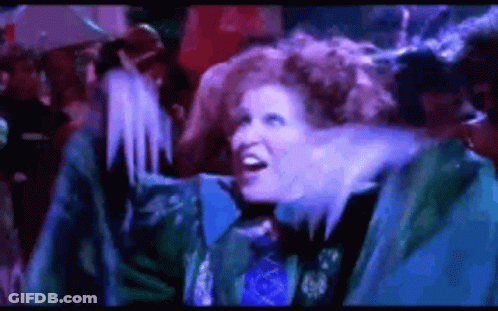 Redhead Woman Standing In Front Of Crowd In Dark Room GIF