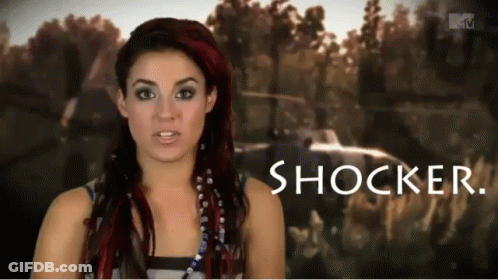 Redhead Woman Standing In Front Of Shocker Sign GIF