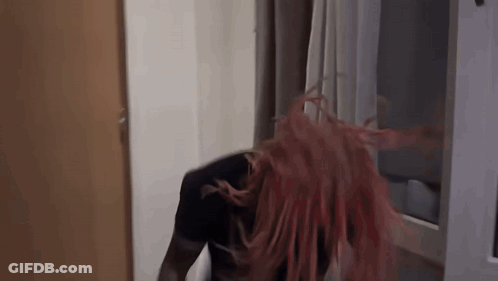 Redhead Woman Standing In Front Of Window Hair Blowing In Wind GIF