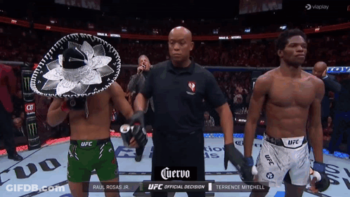 Referee Between Two Fighters In UFC Shorts And Sombrero GIF