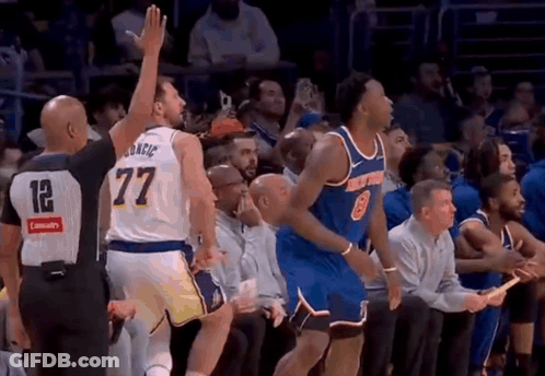 Referee Giving High Five To Basketball Player On Bench GIF