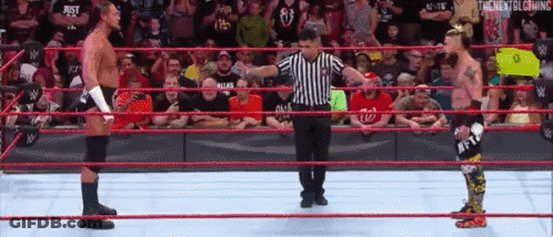 Referee In Wrestling Ring With Two Wrestlers GIF