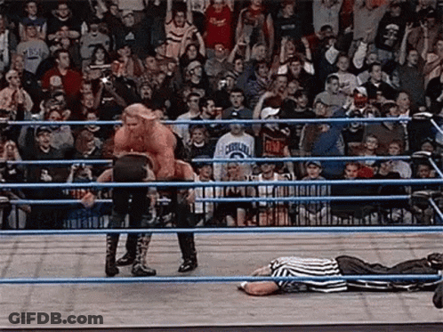 Referee Lying In Ring As Wrestler Jumps Over Him GIF
