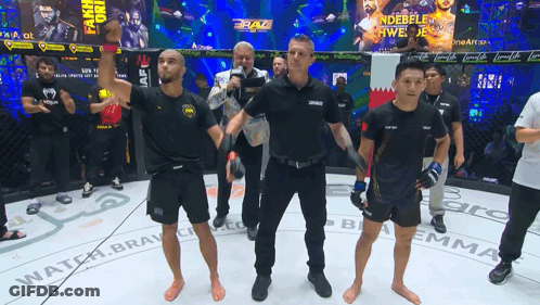 Referee Raising Fighter's Hand In Cage With Braz Banner GIF