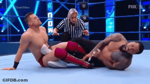Referee Standing Between Two Men In Wrestling Ring GIF