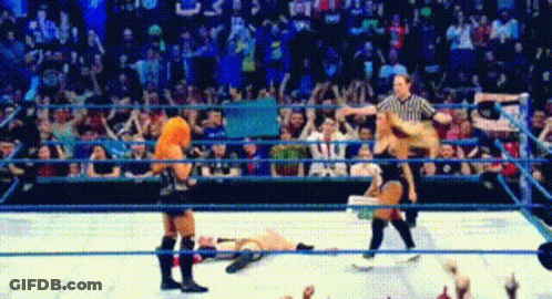 Referee Standing Over Downed Wrestler In Ring GIF