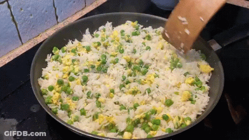 Rice And Peas Are Being Stirred In A Frying Pan GIF