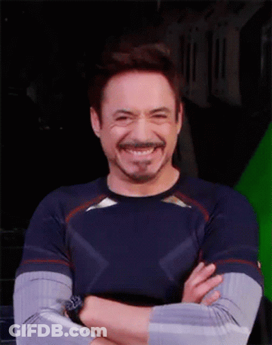 Robert Downey Jr. Is Smiling With His Arms Crossed In Front Of A Green Screen GIF