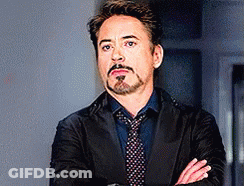 Robert Downey Jr. Is Wearing A Suit And Tie And Has His Arms Crossed . GIF
