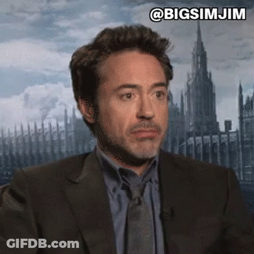 Robert Downey Jr. Is Wearing A Suit And Tie And Making A Face . GIF