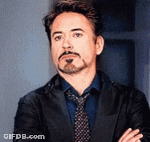 Robert Downey Jr. Is Wearing A Suit And Tie And Making A Funny Face . GIF